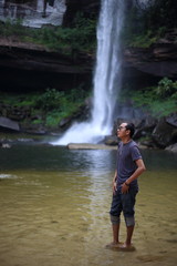 Man standing at Huai Luang Waterfall in Phu Chong–Na Yoi National Park Ubon Ratchathani, Thailand