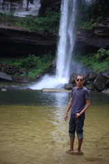 Fototapeta na wymiar Man standing at Huai Luang Waterfall in Phu Chong–Na Yoi National Park Ubon Ratchathani, Thailand