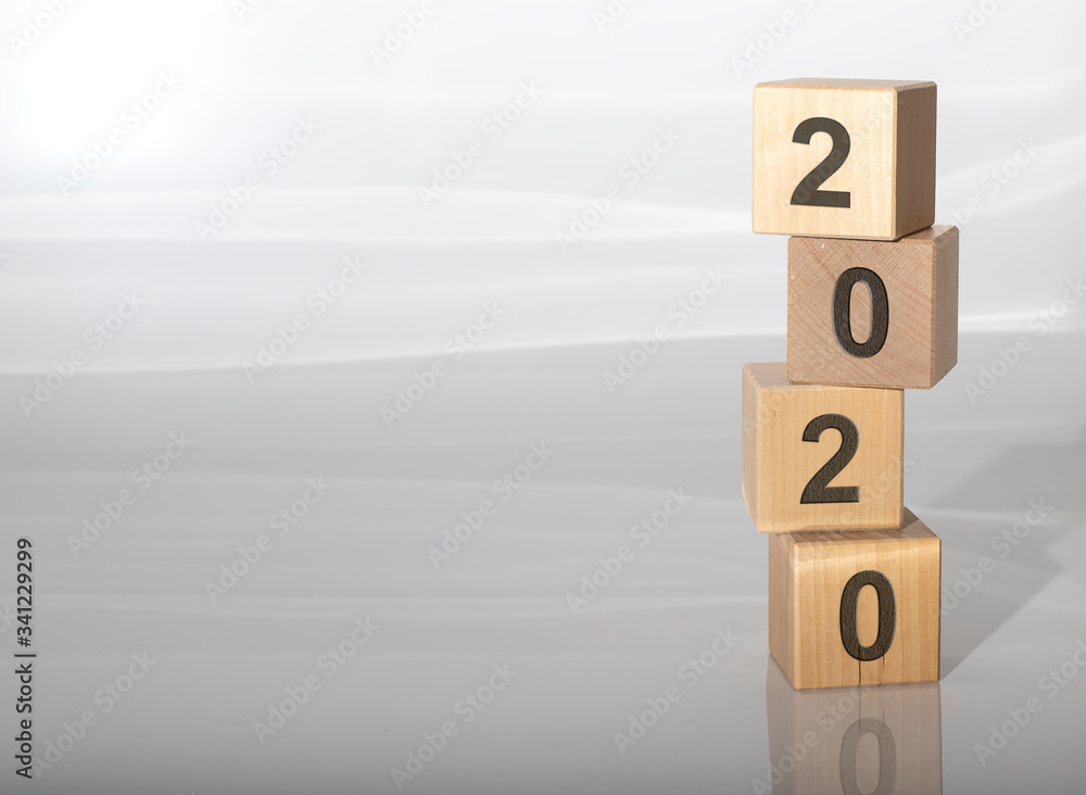 Poster wooden block cube of 2020 year number on light grey glossy background, mininalism. year recap. year 