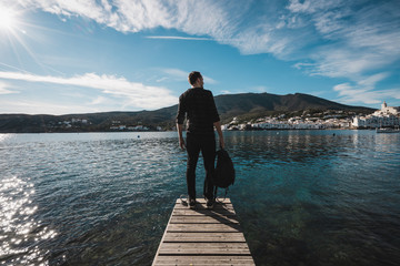 hombre mirando al puerto con aguas azules y verdes