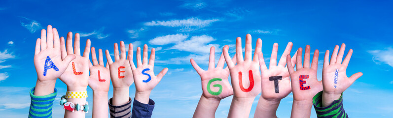 Children Hands Building Colorful German Word Alles Gute Means Best Wishes. Blue Sky As Background