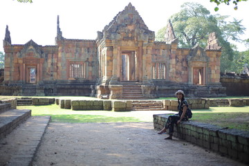 Obraz premium Woman sitting at Prasat Mueang Tam (Mueang Tam castle) in Buriram, Thailand