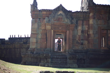 The woman is at the entrance of Prasat Mueang Tam (Mueang Tam castle) in Buriram, Thailand