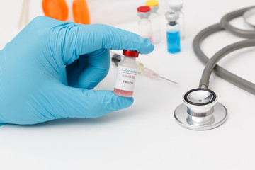 Obraz premium Scientist holding covid-19 vaccine bottle in laboratory.