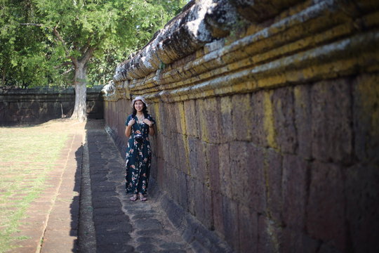 A woman by the wall of Prasat Mueang Tam (Mueang Tam castle) in Buriram, Thailand