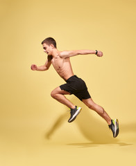 Fototapeta na wymiar Side view of sportsman running in studio