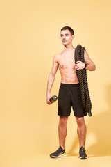 Young athlete man with rug and a rope in studio