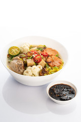 chicken noodle soup with hot sauce on white background