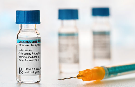Chloroquine phosphate drug in small injection bottles with blue caps, orange green syringe near, closeup detail (own label design with dummy data - not real product) Potential coronavirus cure concept