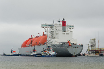 Fototapeta premium LNG TERMINAL AND GAS TANKER - A large ship maneuvers into the unloading quay 