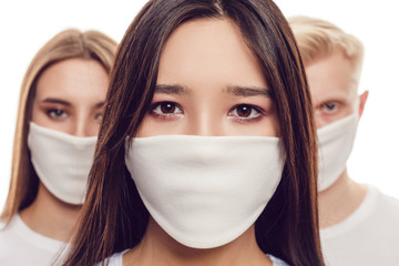 Young people in protective face masks isolated on white.