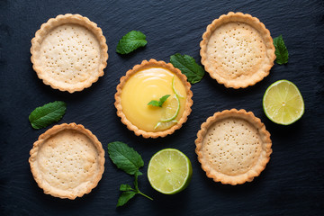 Food concept Homemade organic Lemon, lime tarts or mini pie on black slate stone board