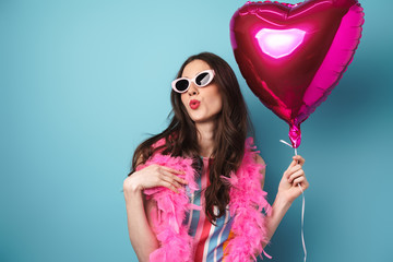 Photo of charming young woman making kiss lips and holding balloon