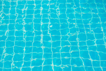 Fototapeta na wymiar Reflections from the water in the blue swimming pool