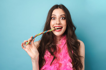 Photo of excited woman in feather boa smiling and eating candy