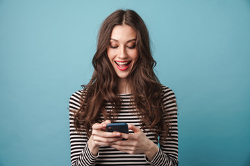 Photo of excited nice woman smiling and using cellphone