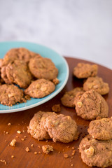 Delicious crunchy homemade chocolate cookies with walnut chunk on top of wooden table and white background.