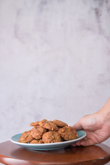 Delicious crunchy homemade chocolate cookies with walnut chunk on top of wooden table and white background.