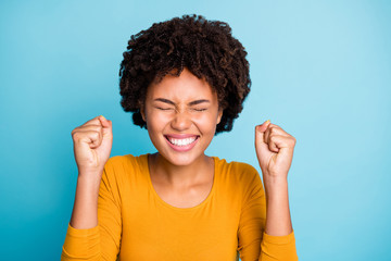 Close up photo funky excited afro american girl wait her ideal perfect birthday present gift surprise raise fists close eyes wear stylish trendy sweater isolated blue color background