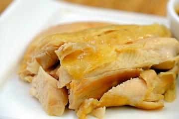 Sliced Hainan-style boiled chicken in white plate.