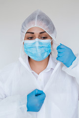 Doctor woman wearing hygienic mask to prevent infection. Coronavirus 2019-nCoV protection concept. Young female wearing protective latex gloves and face mask, close-up.