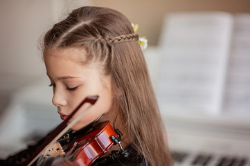 Home lesson for a girl playing the violin. The idea of activities for children during quarantine....
