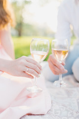 female and male hands hold glasses of wine