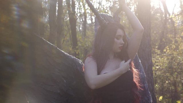 Awesome busty brunette lady maleficent witch standing in the forest stroking herself