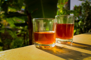 Outdoor Tea pouring into glass cup transparent with day sunlight.
