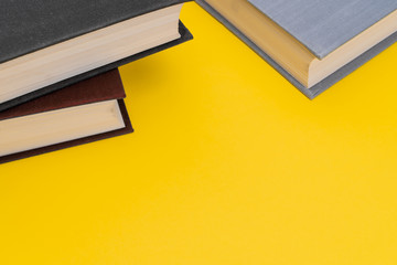 Books on a yellow background. Binding of the books closeup. The books is on the top part of the...