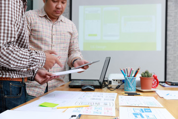 Graphic designers work together with UX UI designer planning application template layout framework for mobile phone computer mobile