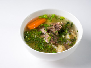 Shurpa soup. Beef with potatoes and carrots in a broth in a white bowl. Side view