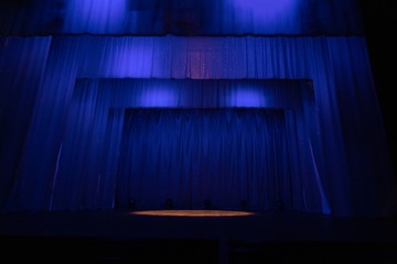 An empty stage of the theater, lit by spotlights and smoke before the performance