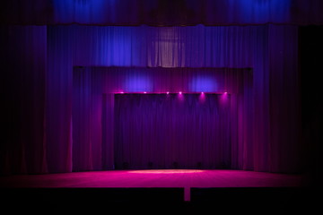 An empty stage of the theater, lit by spotlights and smoke before the performance