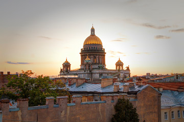 A magnificent view of St. Isaac's Cathedral at sunset from the rooftops. Top view of the city of St. Petersburg. Beautiful sunset in Petersburg, Russia. City rooftops.