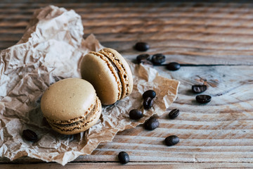 Deux macarons au café et grains de café sur une table en bois