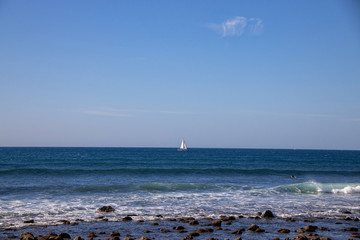  landscape from the Spanish Canary Island of Gran Canaria with the ocean, sky and white sailboat on...