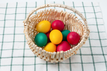 multicolored painted eggs in a wicker basket