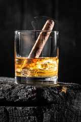 Cigar put out in a glass of whiskey