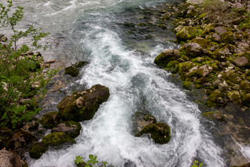 A small waterfall. Fast river in the spring and stones.