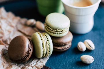 Macarons au chocolat et à la pistache sur une planche ardoise