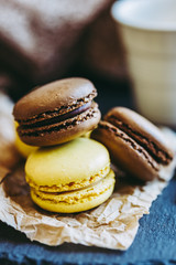 Fototapeta premium Macarons parfum citron et chocolat posés sur un fond ardoise