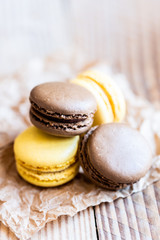 Macarons parfum citron et chocolat posés sur une table en bois
