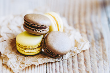 Macarons parfum citron et chocolat posés sur une table en bois