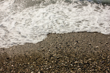 The promenade of the beach. Close-up photo of a wave of the Black Sea in Abkhazia
