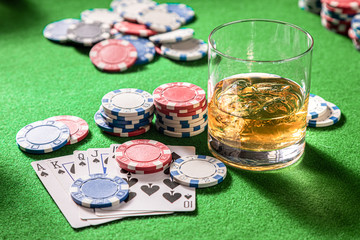 Whisky and cards on four-person gambling table