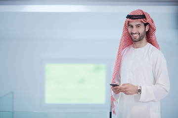 young arabian businessman using smartphone at home