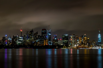 Sydney, Australia - 12th February 2020: A German photographer visiting Sydney in Australia, taking pictures of the skyline with the Opera house during a cloudy but warm day in summer at night.
