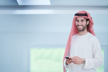 young arabian businessman using smartphone at home