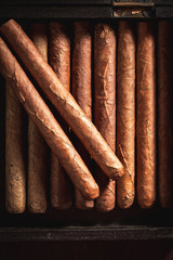 Top view of cigars lay in wooden humidor